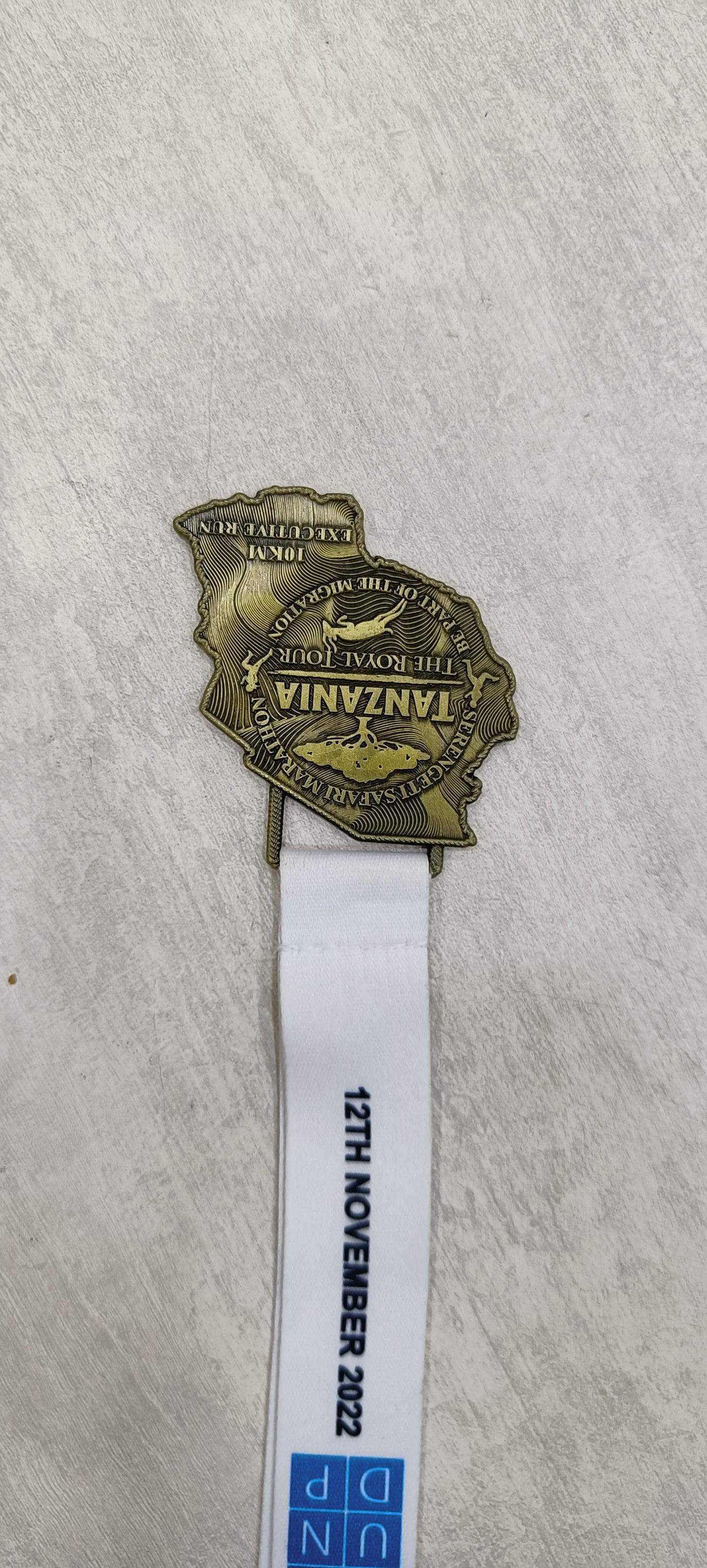 Tanzania Marathon custom medal with lanyard; commemorating the 2022 event. Ideal for sports prizes or corporate awards.